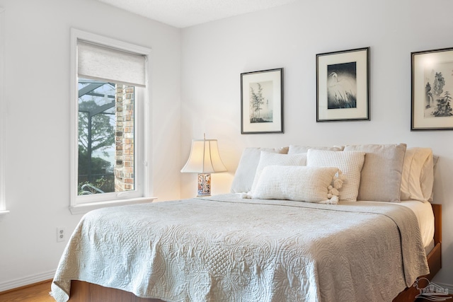 bedroom with baseboards and wood finished floors