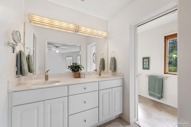 full bath featuring double vanity, a textured ceiling, and a sink