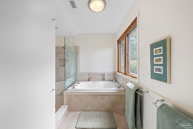 bathroom with tile patterned flooring, visible vents, a garden tub, and tiled shower