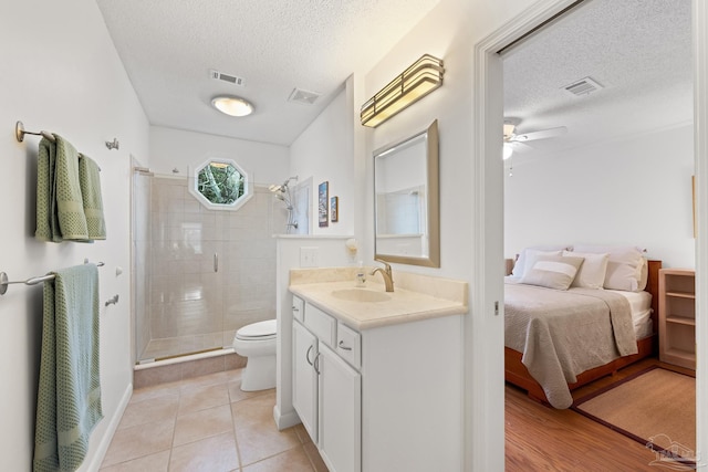 ensuite bathroom with visible vents, connected bathroom, a textured ceiling, and toilet