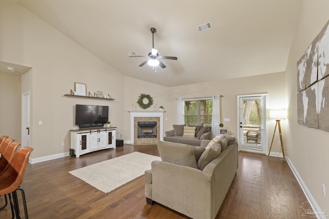 living area featuring high vaulted ceiling, dark wood-style flooring, visible vents, baseboards, and a tiled fireplace