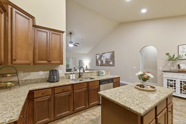 kitchen with light stone counters, a sink, and a center island