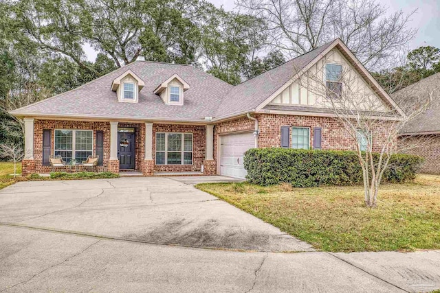 view of front of home with driveway, brick siding, a shingled roof, an attached garage, and a front yard