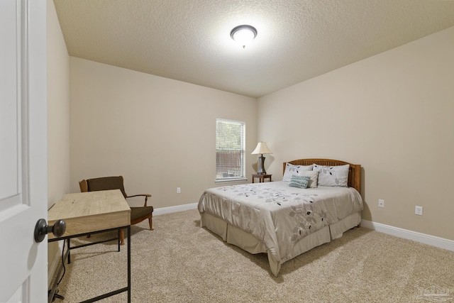 bedroom featuring light carpet, baseboards, and a textured ceiling