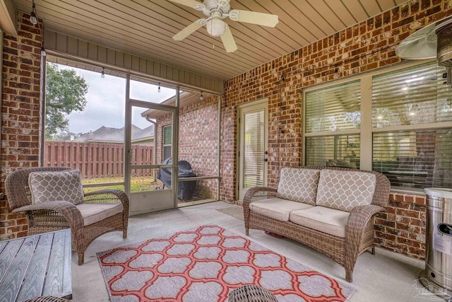 sunroom featuring wood ceiling and a ceiling fan