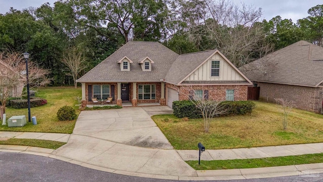 view of front of house featuring brick siding, a porch, a garage, driveway, and a front lawn