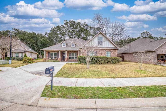 view of front of property with brick siding, a front yard, and aphalt driveway