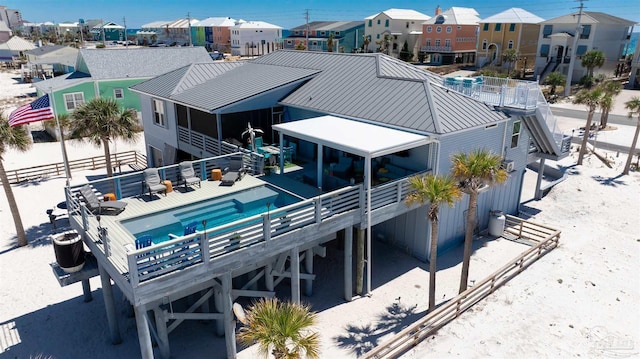 back of house featuring a residential view, a standing seam roof, and metal roof