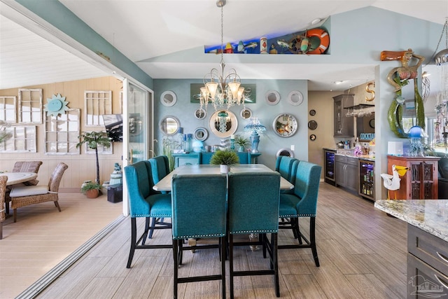 dining area with an inviting chandelier, light wood-style flooring, wine cooler, and vaulted ceiling