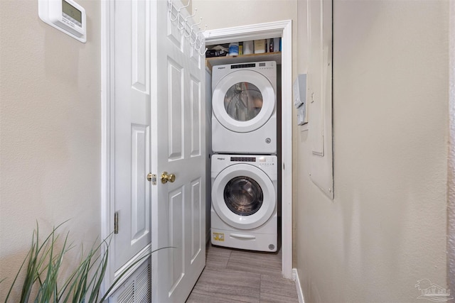 laundry room featuring stacked washer / drying machine and laundry area