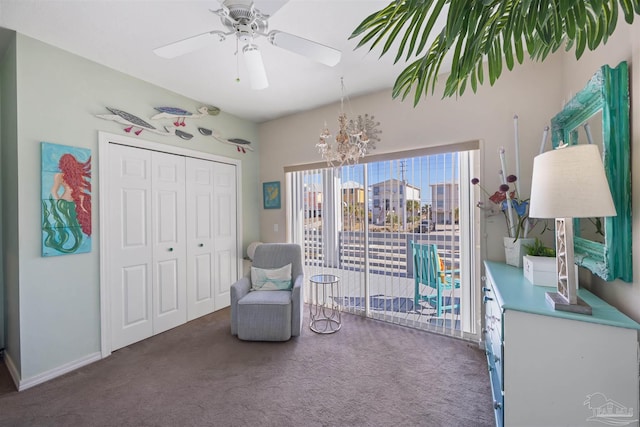 living area featuring baseboards, carpet, and ceiling fan with notable chandelier