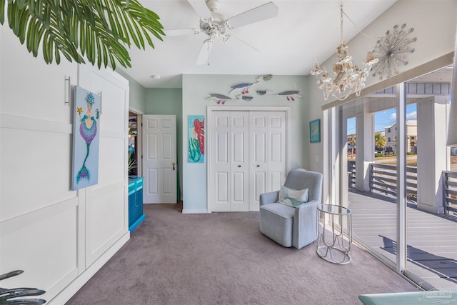 living area with carpet floors and ceiling fan with notable chandelier