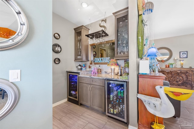 bar featuring baseboards, beverage cooler, and indoor wet bar