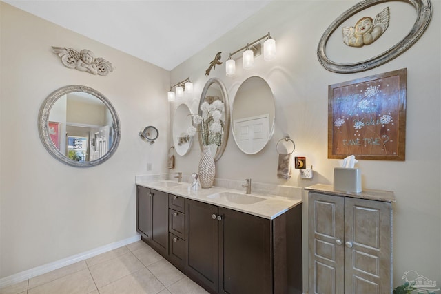 bathroom featuring tile patterned floors, double vanity, a sink, and baseboards