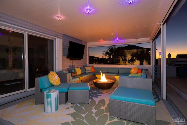 view of patio with an outdoor living space with a fire pit