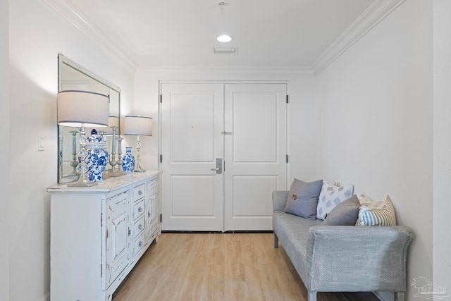 living area with light hardwood / wood-style flooring and crown molding