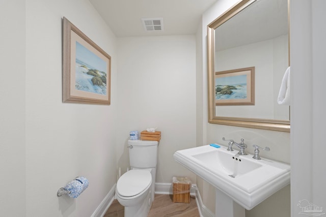 bathroom featuring hardwood / wood-style floors, toilet, and sink