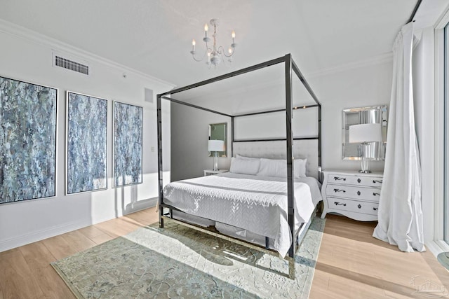 bedroom with a chandelier, light hardwood / wood-style floors, and crown molding