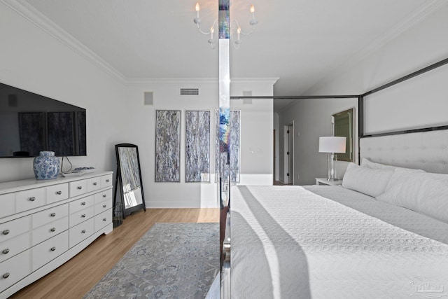 bedroom featuring light wood-type flooring, ornamental molding, and an inviting chandelier