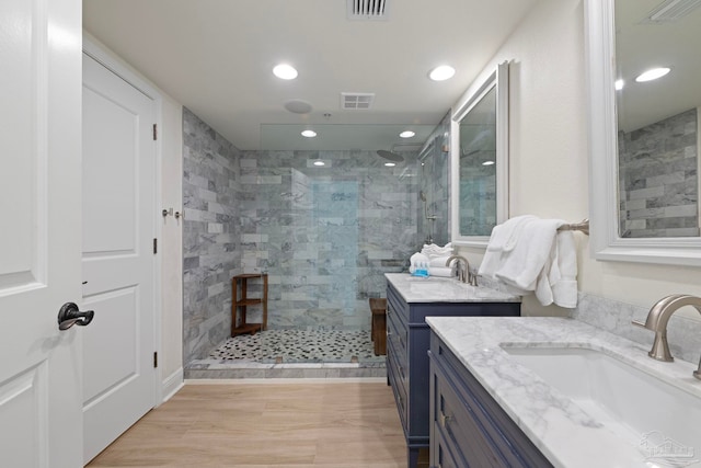 bathroom with vanity, tiled shower, and hardwood / wood-style flooring