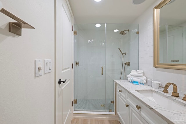 bathroom with an enclosed shower, vanity, and hardwood / wood-style flooring