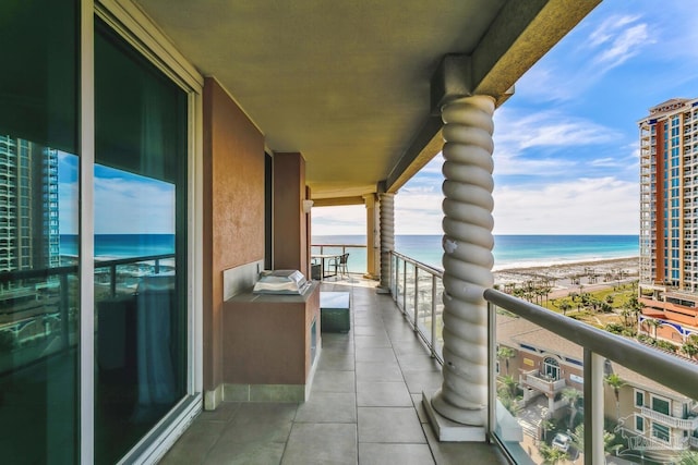 balcony featuring a view of the beach and a water view