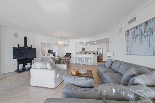 living room featuring light hardwood / wood-style flooring and crown molding