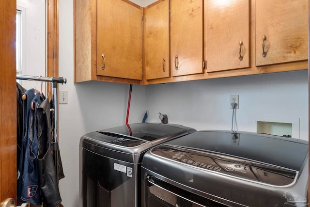 washroom featuring cabinet space and independent washer and dryer