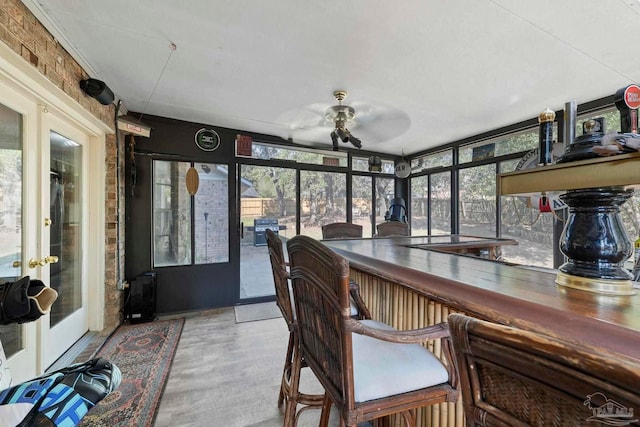 sunroom featuring french doors and a ceiling fan