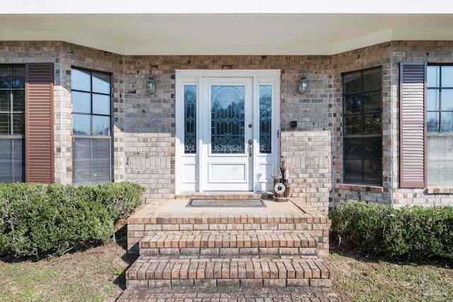 entrance to property featuring brick siding