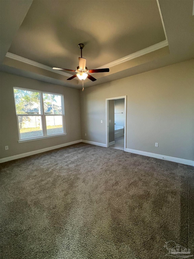 empty room featuring carpet flooring, a tray ceiling, and ceiling fan