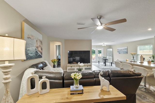 living room with ceiling fan, wood-type flooring, and plenty of natural light