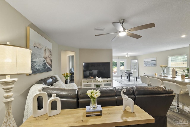 living area featuring ceiling fan, wood finished floors, and visible vents