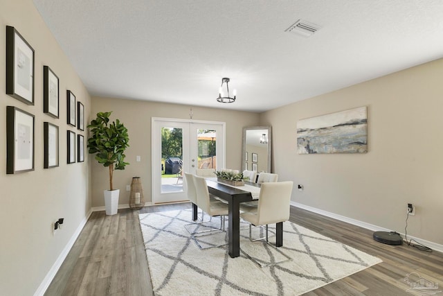 dining area featuring hardwood / wood-style floors, french doors, and a textured ceiling