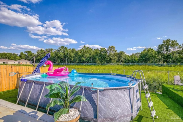 view of pool with a lawn, a fenced backyard, and a fenced in pool