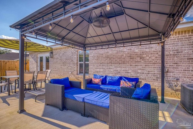 view of patio featuring central air condition unit, an outdoor hangout area, fence, a gazebo, and french doors