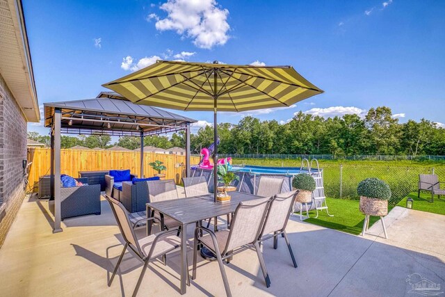 view of patio featuring outdoor lounge area, a gazebo, and a fenced in pool