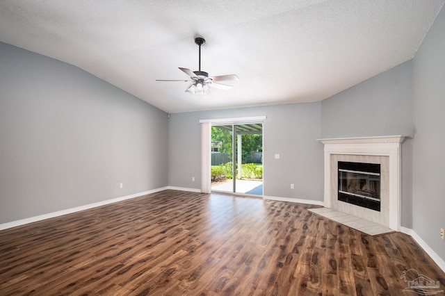 7292 Broadmoor St, Navarre, FL 32566 - unfurnished living room featuring dark wood-style flooring, ceiling fan, a fireplace, vaulted ceiling, and a textured ceiling