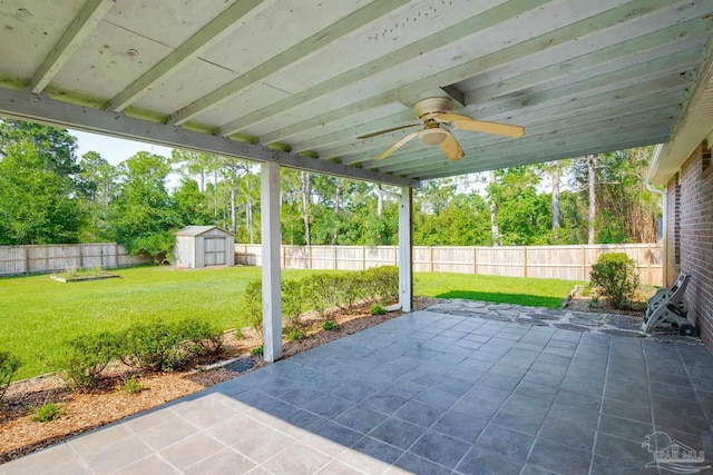 7292 Broadmoor St, Navarre, FL 32566 - fenced backyard with a ceiling fan, a patio area, a storage shed, and view of wooded area