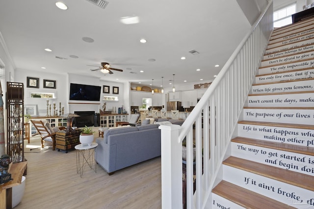 living room featuring light wood-style floors, recessed lighting, visible vents, and a fireplace