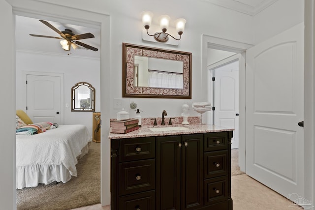 ensuite bathroom featuring ensuite bathroom, tile patterned flooring, ceiling fan with notable chandelier, vanity, and ornamental molding