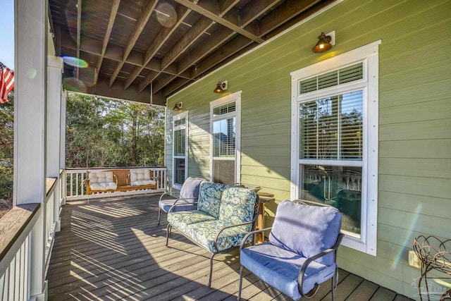 wooden terrace with covered porch and an outdoor living space