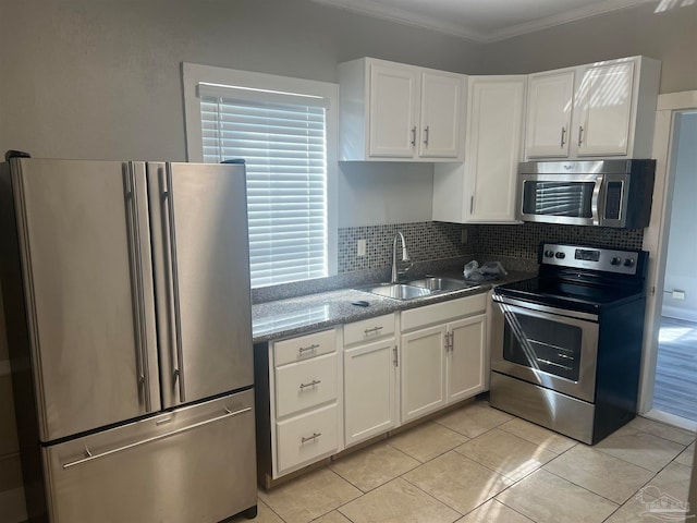 kitchen with stainless steel appliances, white cabinets, crown molding, and sink