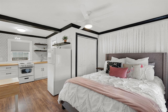 bedroom with white refrigerator, a closet, hardwood / wood-style floors, ceiling fan, and sink