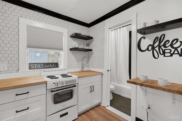 kitchen featuring butcher block countertops, white range, light wood-type flooring, and white cabinets