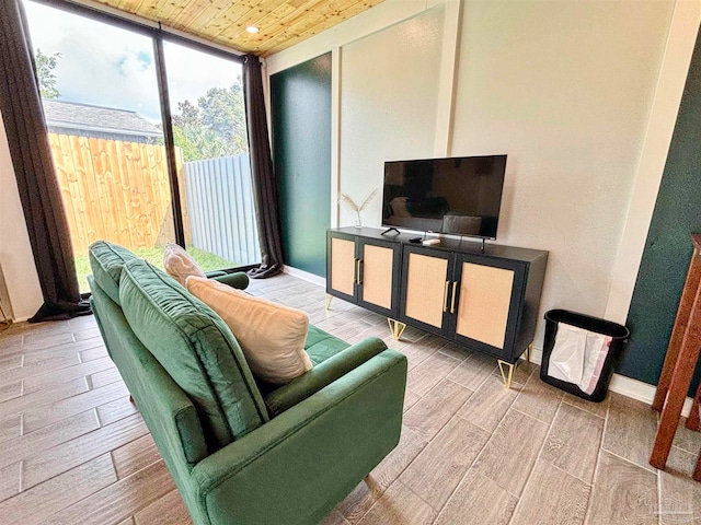 living room featuring light wood-type flooring, wood ceiling, and floor to ceiling windows