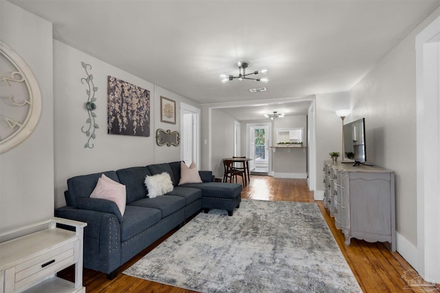 living room with a notable chandelier and dark hardwood / wood-style flooring