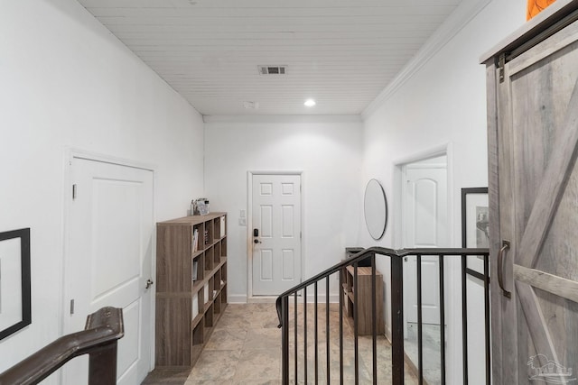 hallway with a barn door, wooden ceiling, and crown molding