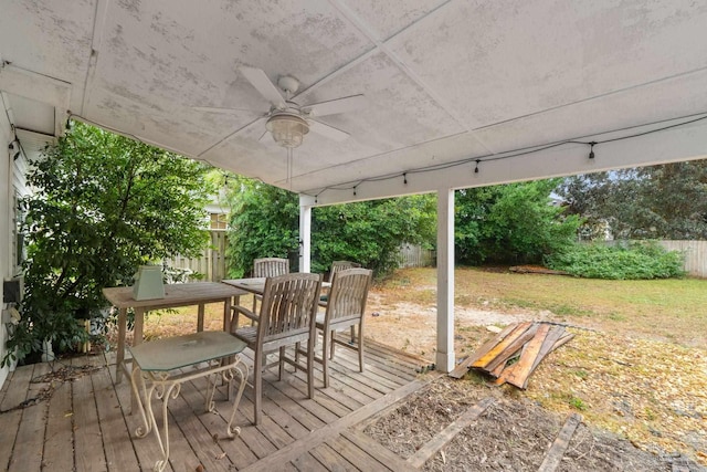 wooden terrace with ceiling fan and a yard