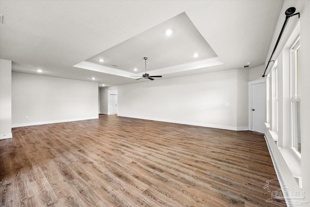 10826 Blacktail Loop, Pensacola, FL 32526 - unfurnished living room featuring a raised ceiling, ceiling fan, recessed lighting, wood finished floors, and baseboards